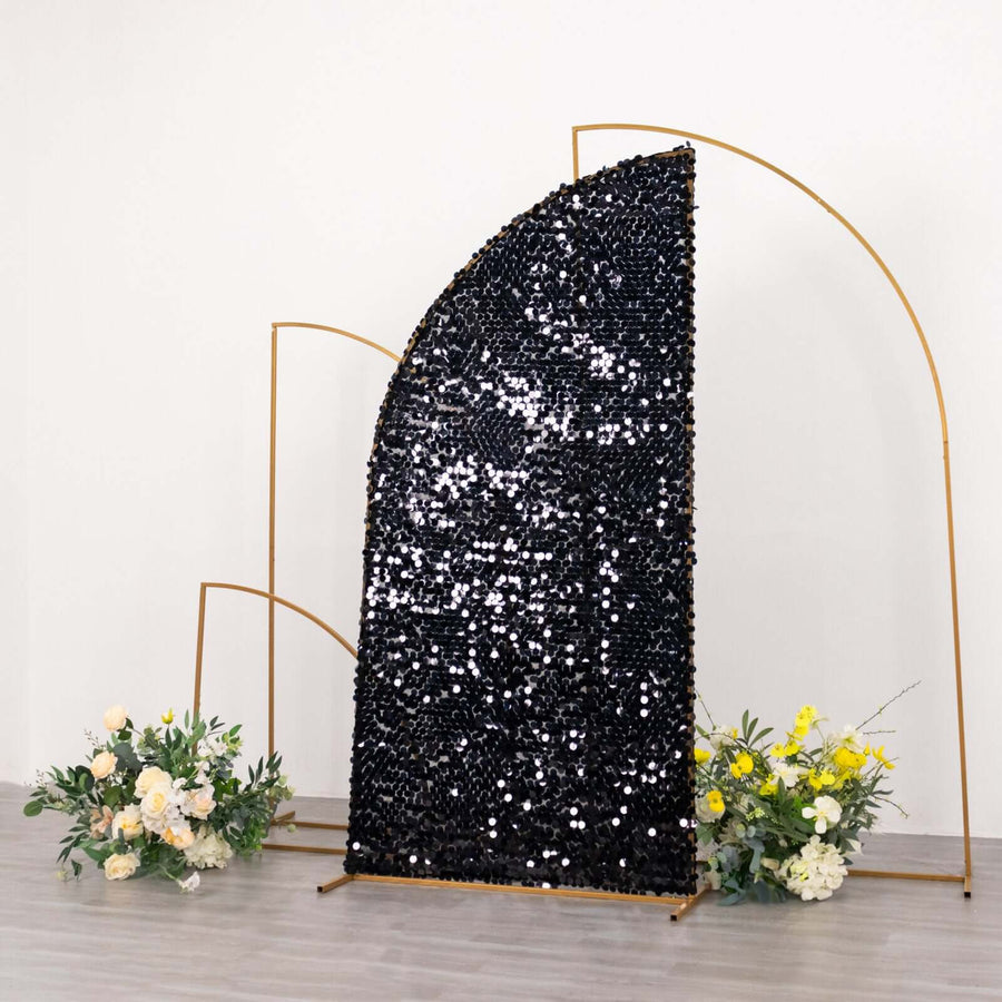 Black sequin backdrop with gold arches and floral accents in a studio setting.
