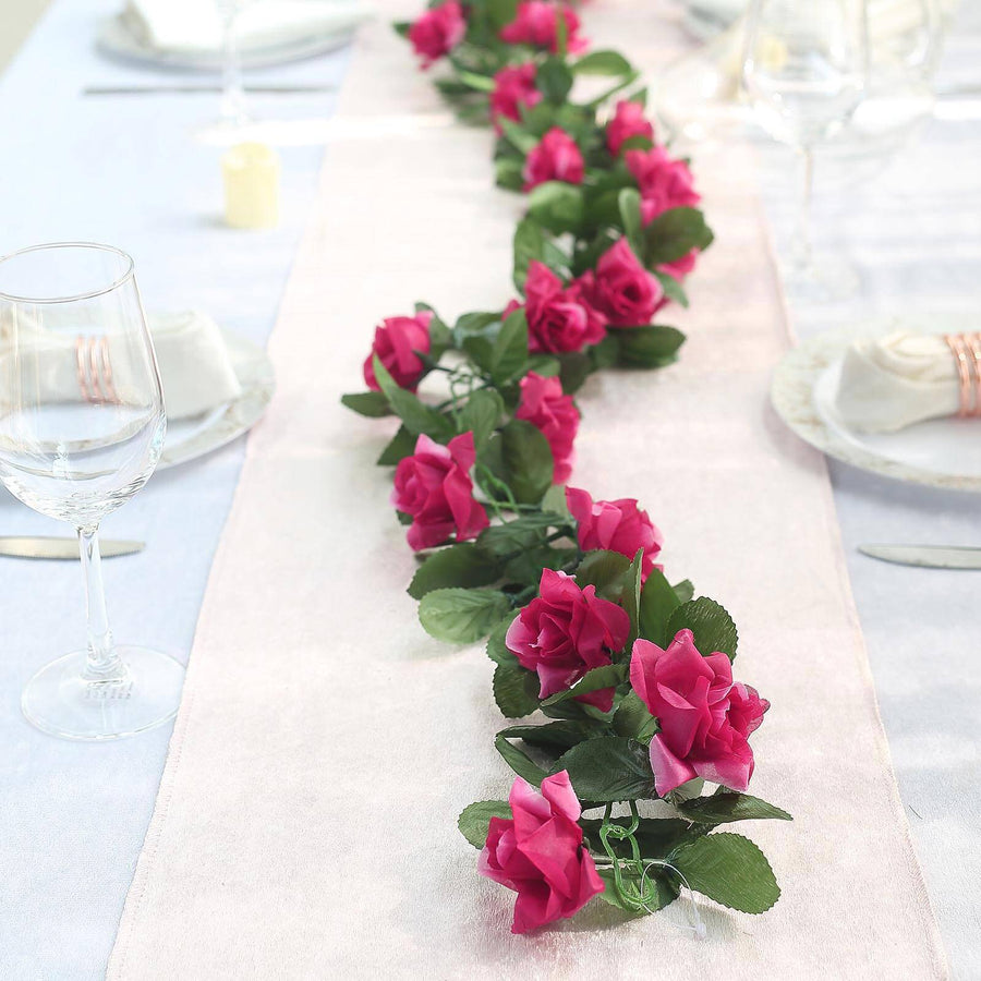 Pink rose garland centerpiece on a dining table with elegant table settings.