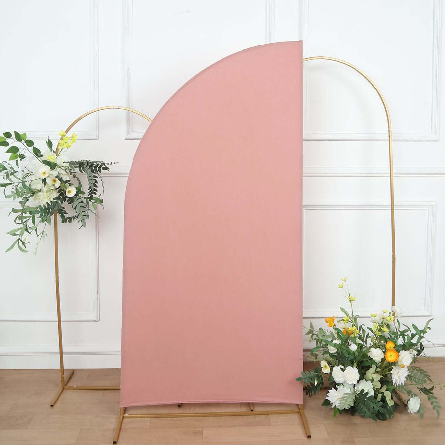 Pink curved backdrop with gold stands and floral arrangements on either side.