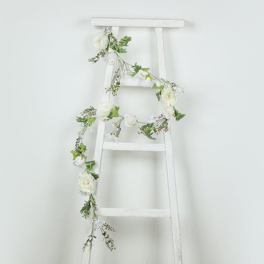 White floral garland draped on a white wooden ladder