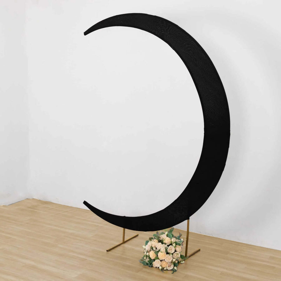 Black crescent moon backdrop with floral arrangement at its base