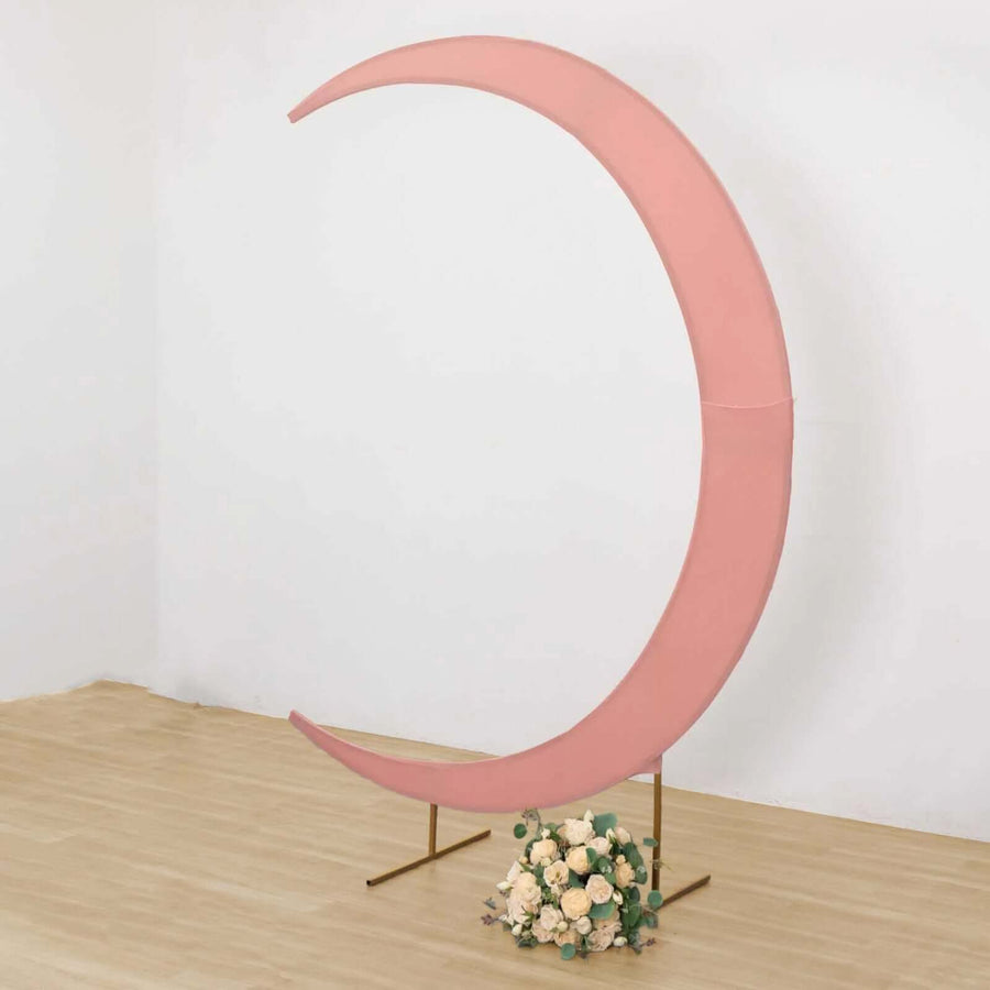 Pink crescent moon backdrop with floral arrangement at the base.