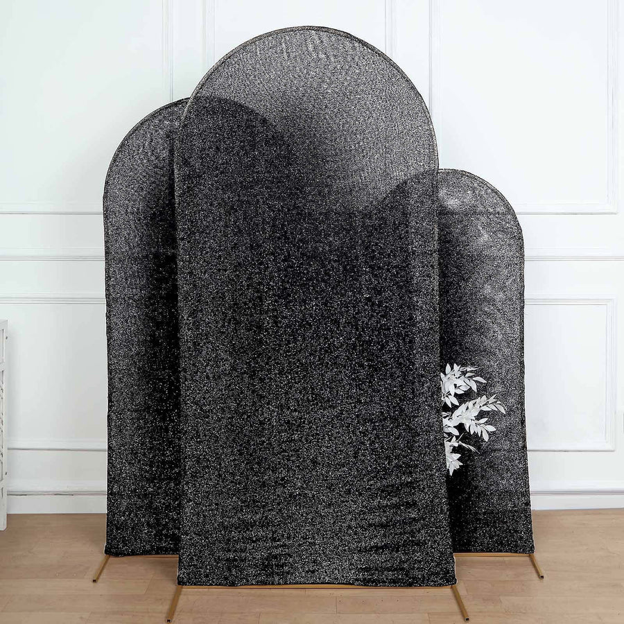 Three black decorative screens with curved tops in a minimalist setting.