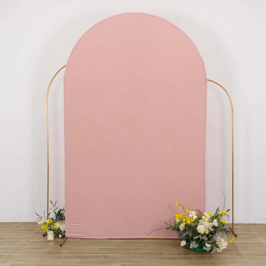 Pink arch backdrop with floral arrangements on the floor.