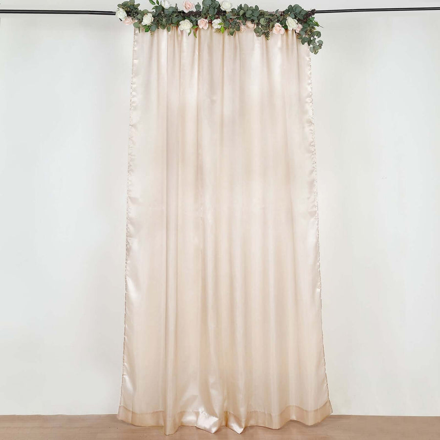 Blush satin backdrop curtain with floral garland on wall