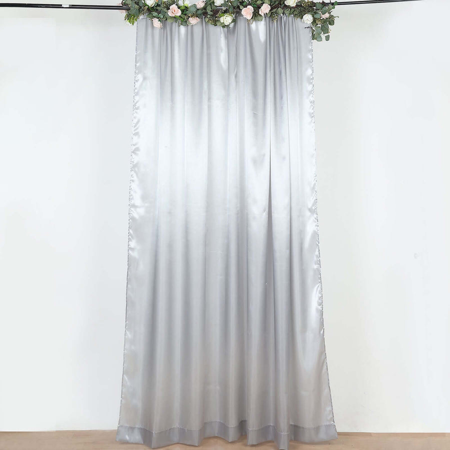 Silver sheer curtain with floral garland on display wall
