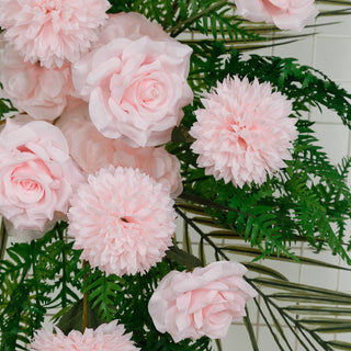 Pink roses and flowers with greenery on a plain background.