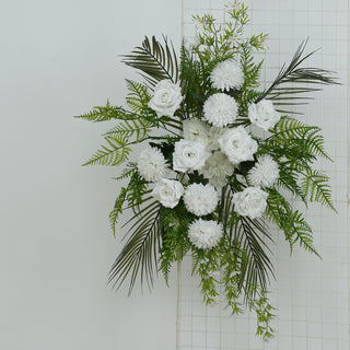White floral arrangement with roses and ferns on a white background.