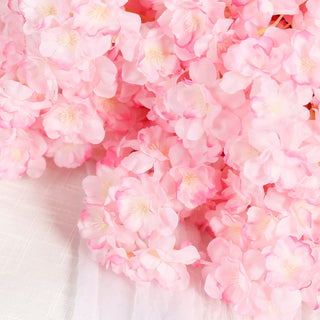 Pink artificial flowers bouquet on textured fabric.