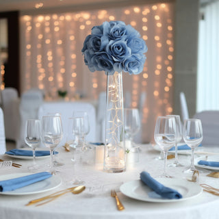 Blue rose centerpiece with fairy lights on an elegantly set dining table.