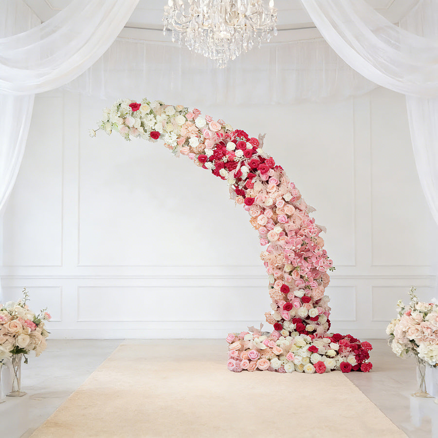 Floral arch made of pink and white roses in an elegant venue setting.