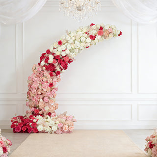 Floral arch arrangement in shades of pink and red for events and weddings.