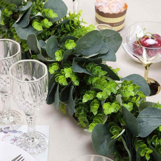Decorative green foliage garland on a dining table with glassware and desserts.