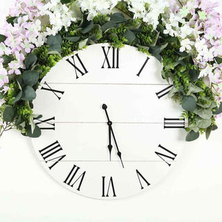 Floral wall clock with Roman numerals and greenery accents