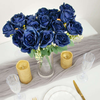 Navy blue rose bouquet in a glass vase on a dining table.