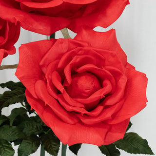 Red artificial rose flower with green leaves for decoration.