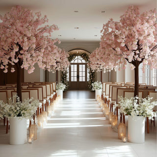 Elegant wedding ceremony setup with pink cherry blossom trees and floral arrangements.