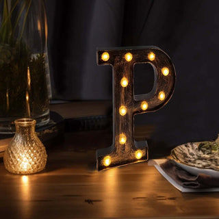 Illuminated letter "P" marquee light on a wooden table