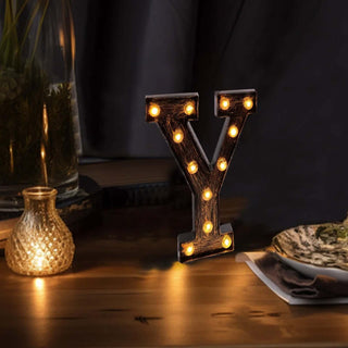 Decorative light-up letter 'Y' on a wooden table with ambient lighting.
