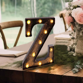 Vintage illuminated letter "Z" decorative sign on a rustic table.
