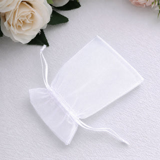 White organza gift pouch with drawstring on soft fabric with roses