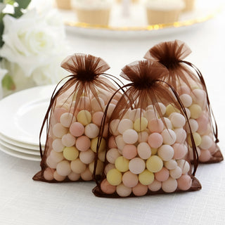 Pastel candy bags on a table with white plates in the background.