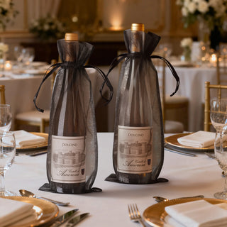 Elegant wine bottles in black mesh bags on a beautifully set dining table.