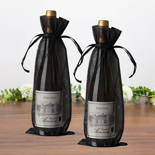 Dolcino wine bottles in elegant black gift bags on a wooden surface.