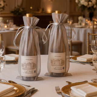 Elegant wine bottles in decorative bags on a beautifully set dining table.