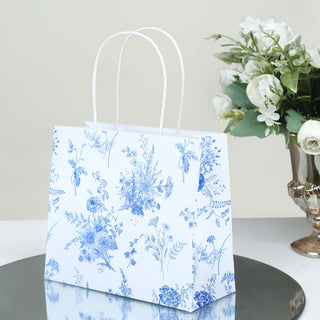 Floral patterned gift bag on a mirrored surface with decorative flowers.