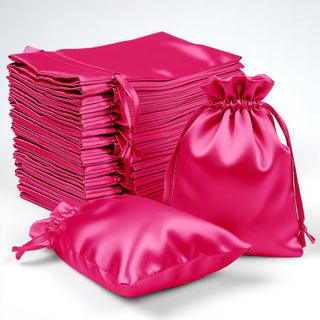 Stack of vibrant pink satin drawstring bags on a white background