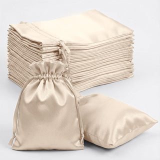 Set of luxurious satin drawstring bags in beige, ideal for gifts or storage.