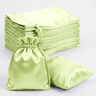 Set of green satin pouches and pillowcases stacked neatly.
