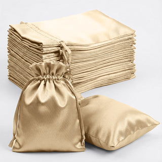 Set of gold satin drawstring bags and pillowcases on a white background.