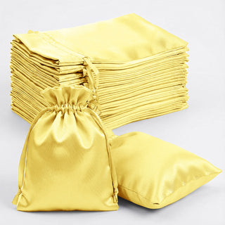 Set of yellow satin bags, including a drawstring pouch and flat cushion.
