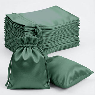 Green satin drawstring bags and pouches stacked together.