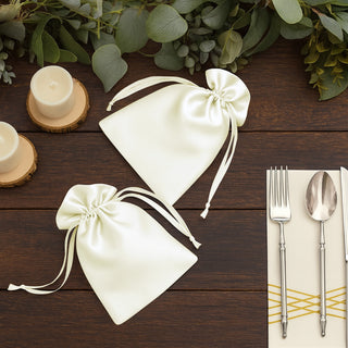 Elegant ivory satin drawstring bags on a rustic wooden table.