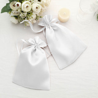 Two elegant white satin drawstring bags on a soft surface.