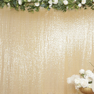 Elegant gold sequin backdrop with floral arrangement for events and photography.