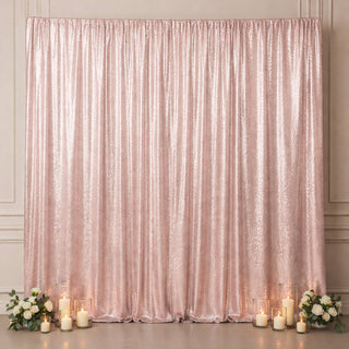 Rose gold sequin backdrop with candles and floral arrangements.