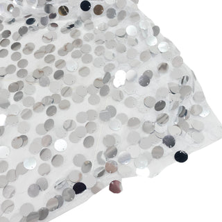 White sequin fabric close-up with reflective silver discs