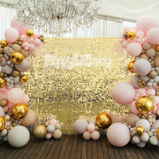 Birthday party backdrop with colorful balloons and a sparkling golden wall.