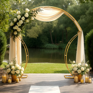 Elegant wedding arch adorned with roses, drapes, and candles by a serene pond.
