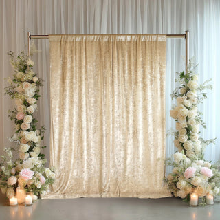 Elegant beige velvet backdrop with floral arrangements and candles for events.