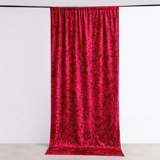 Red velvet curtain hanging against a plain backdrop