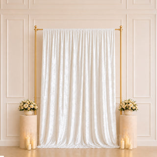 Elegant white wedding backdrop with gold frame, floral arrangements, and candles