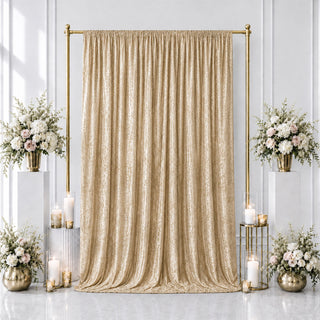 Elegant gold wedding backdrop with beige drapes, floral arrangements, and candles