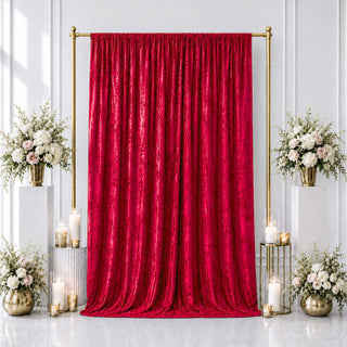 Red velvet backdrop with gold frame, white floral arrangements, and candles