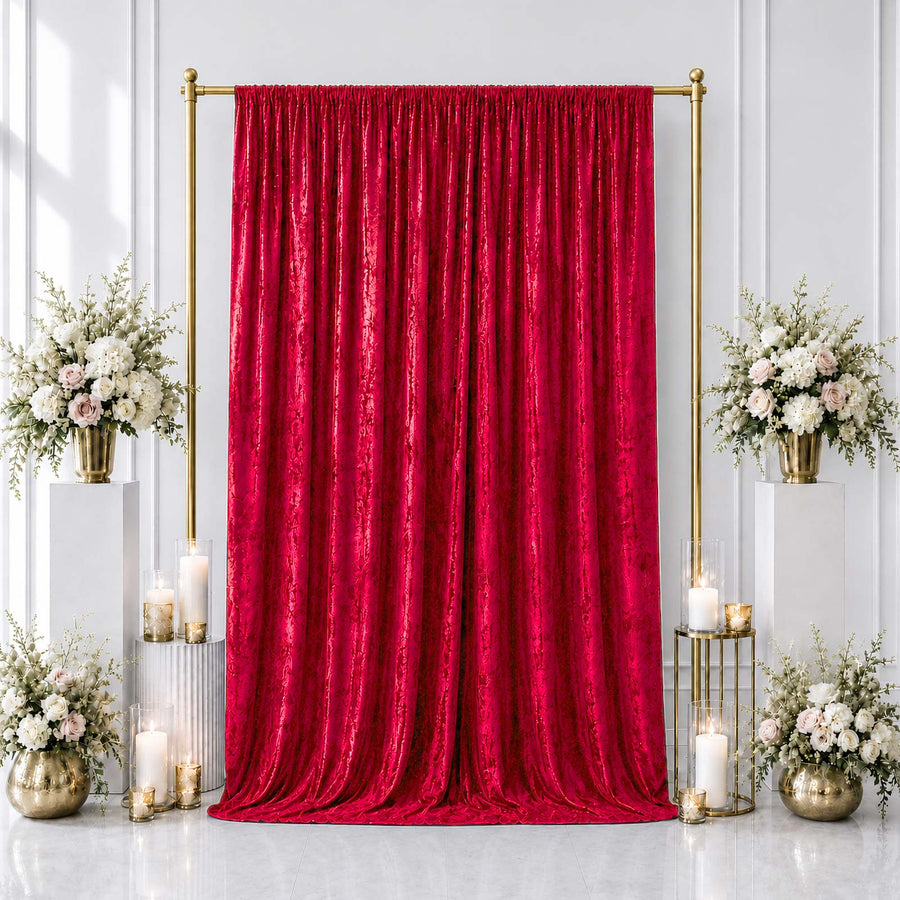 Red velvet backdrop with gold frame, white floral arrangements, and candles