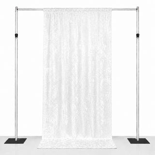 White patterned backdrop curtain on adjustable metal stand with weighted bases